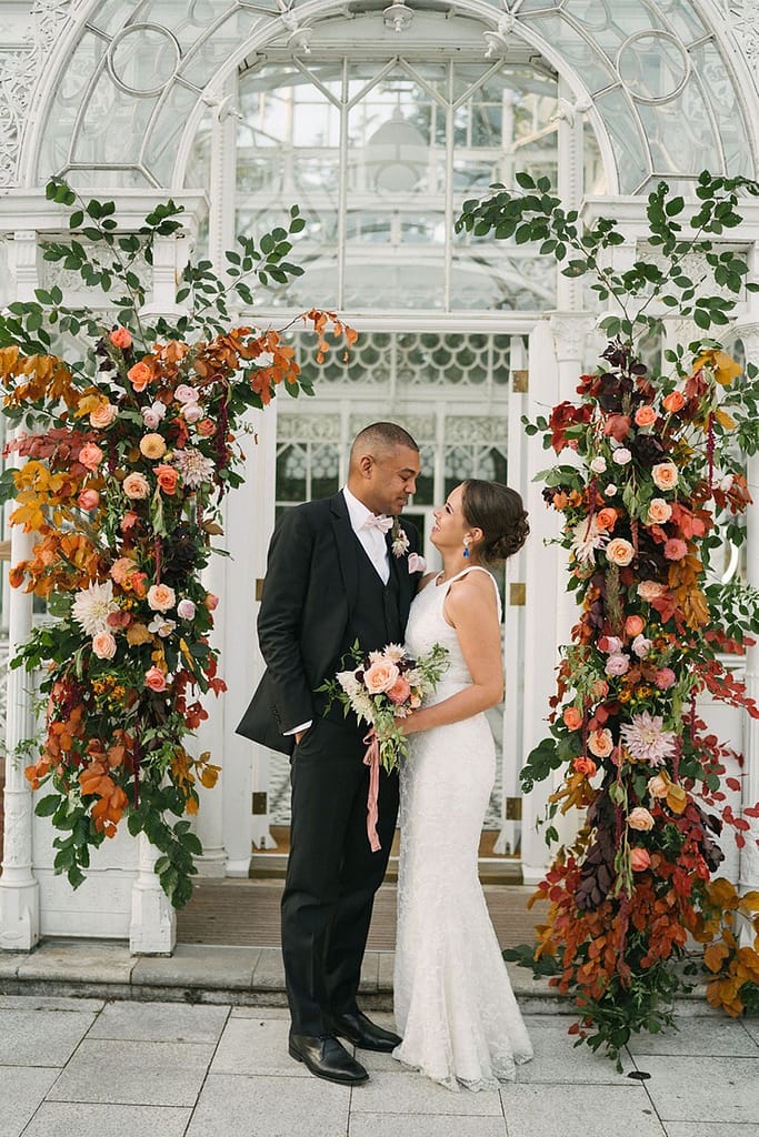 Bride and Groom with Autumnal Deconstructed Flower Arch