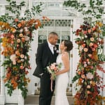 Bride and Groom with Wedding Flower Arch