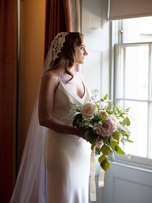 Bride Holding Bouquet at Window
